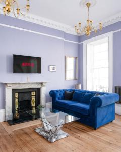 a blue couch in a living room with a fireplace at Darcys' View in Bath