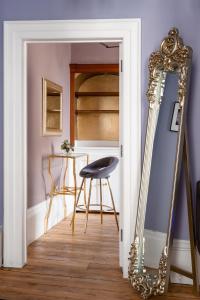 een kamer met een stoel en een spiegel bij Darcys' View in Bath
