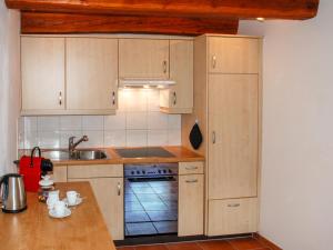 a kitchen with wooden cabinets and a stove top oven at Holiday Home Rustico Ca' di Garoi by Interhome in Malvaglia +40 photos