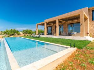 eine Villa mit einem Swimmingpool vor einem Haus in der Unterkunft Villa Can Navarro by Interhome in Inca