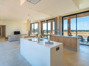 eine Küche und ein Wohnzimmer mit großen Fenstern in der Unterkunft Villa Can Navarro by Interhome in Inca