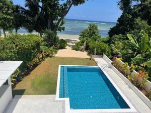 a swimming pool with a view of the ocean at Lyla Beach Villa in Pointe Au Sel 