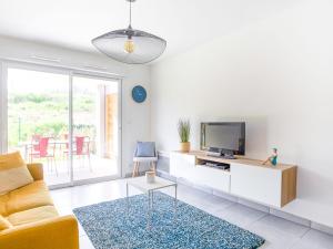 - un salon avec une télévision et un canapé dans l'établissement Apartment Royal Green by Interhome, à Roquebrune-sur Argens