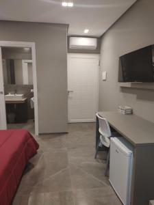 a bedroom with a bed and a desk and a bathroom at Hotel Valle Verde in Grammichele
