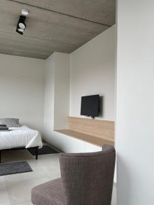 Un dormitorio con una cama y un televisor en una pared. en BeHome Dilbeek, en Dilbeek