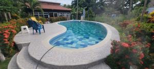 a swimming pool with a chair and a table and some flowers at Indigo Palomino Beautiful House in Palomino