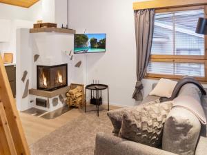 a living room with a couch and a fireplace at Holiday Home Rukaköngäs 20 includes one ski lift tick by Interhome in Ruka