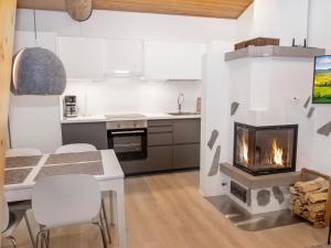 a kitchen with a fireplace and a table and chairs at Holiday Home Rukaköngäs 20 includes one ski lift tick by Interhome in Ruka