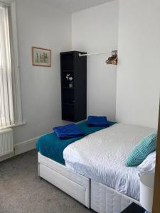 Un dormitorio con una cama con almohadas azules. en Heart of Southsea,near common and sea., en Portsmouth
