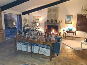 a living room with a table and a fireplace at Le Mas des Cosme in Aramon