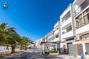 a street in front of a building with palm trees at Apartamentos Vista Alegre Casa Azahar in Alcossebre +7 photos