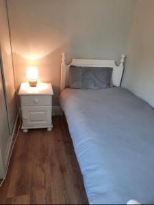 una piccola camera con letto e comodino con lampada di The Villa a Lettermacaward