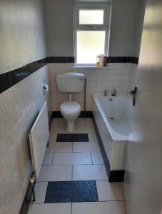a bathroom with a toilet and a tub and a sink at The Villa in Lettermacaward