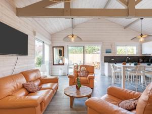 ein Wohnzimmer mit Ledermöbeln und eine Küche in der Unterkunft Holiday Home Villa Horizon by Interhome in Lacanau-Océan