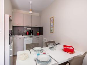 een keuken met een witte tafel met stoelen en een witte tafel sidx sidx bij Studio Résidence le Cotre by Interhome in Saint-Malo