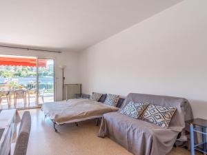 a living room with a couch and a table at Apartment Le Suzy by Interhome in Cavalaire-sur-Mer