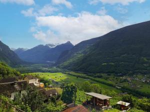 a village in a valley with mountains in the background at Holiday Home Casa Pina by Interhome in Malvaglia