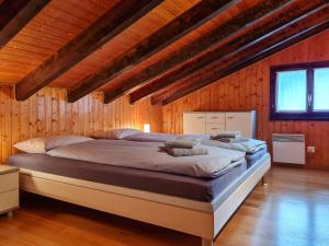 a large bed in a room with wooden walls at Holiday Home Casa Pina by Interhome in Malvaglia