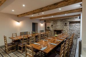 een grote eetkamer met een grote houten tafel en stoelen bij The Greyhound Hotel in Shap