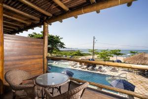 a patio with a table and chairs and a swimming pool at Pousada Pedra da Ilha in Penha