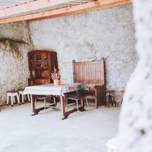 einen Tisch und Stühle in einem Zimmer mit einer Wand in der Unterkunft O Palheiro in Bragança