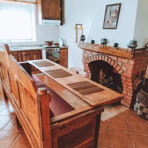 a kitchen with a table and a brick fireplace at O Palheiro in Bragança