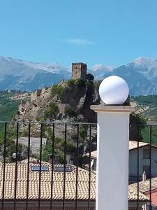 um castelo no topo de uma colina com uma cerca em Primae Noctis Apartments em Roccascalegna