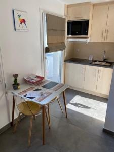 uma pequena cozinha com uma mesa e uma cadeira em Charmant studio à Haguenau, à 25mn de Strasbourg em Haguenau