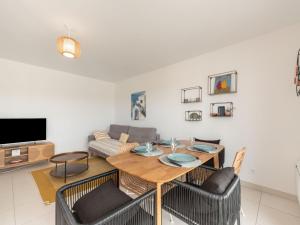 ein Wohnzimmer mit einem Holztisch und Stühlen in der Unterkunft Apartment Eden Riviera by Interhome in Cavalaire-sur-Mer