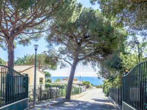 um portão com uma árvore ao lado de uma estrada em Apartment Les Coteaux de la Nartelle-26 by Interhome em Sainte-Maxime