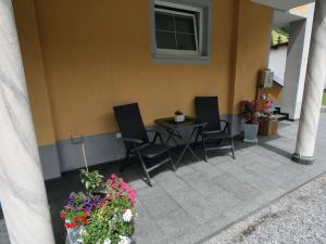a patio with chairs and a table and some flowers at Apartment Sesselebenerhof-2 by Interhome in See