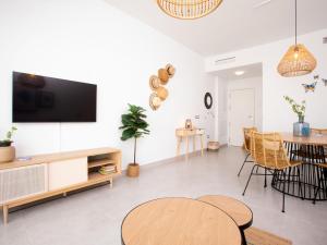 ein Wohnzimmer mit einem Tisch und einem TV an der Wand in der Unterkunft Apartment Piscis by Interhome in Torre del Mar