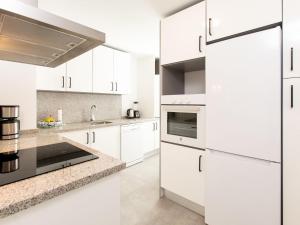eine weiße Küche mit weißen Schränken und Geräten in der Unterkunft Apartment Piscis by Interhome in Torre del Mar