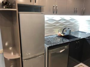 a kitchen with a stainless steel refrigerator and a sink at Ashtarak-1 Modern Apartment in Ashtarak