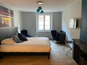 Hotel-Restaurant St-Christophe في بلفور: غرفة نوم بسرير وكرسيين ونافذة