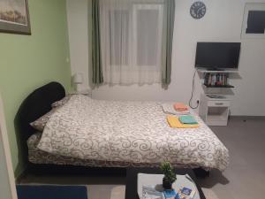 a small bedroom with a bed and a television at Apartmani Irena in Tivat