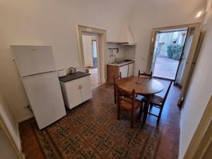 uma cozinha com uma mesa e um frigorífico em Palazzo Mannino Apartments em Catânia