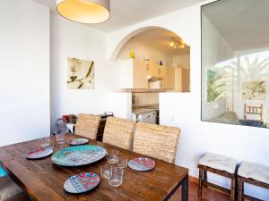 een eetkamer met een houten tafel en stoelen bij Apartment Carabeo by Interhome in Nerja