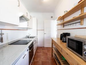 een keuken met witte kasten en een houten aanrecht bij Apartment Carabeo by Interhome in Nerja