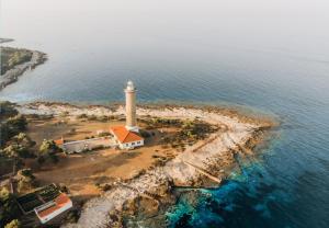 an island with a lighthouse in the water at Veli Rat Lighthouse in Veli Rat