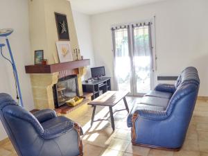 ein Wohnzimmer mit 2 Stühlen und einem Kamin in der Unterkunft Holiday Home Lac et forêt by Interhome in Lacanau