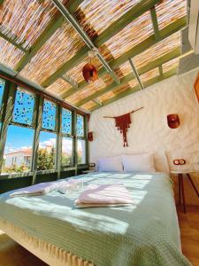 ein Schlafzimmer mit einem Bett in einem Zimmer mit Fenstern in der Unterkunft My Dream Alaçatı in Alacati