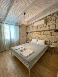 ein Schlafzimmer mit einem Bett mit einer Steinmauer in der Unterkunft My Dream Alaçatı in Alacati