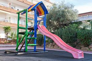 a playground with a colorful slide in a parking lot at APCOSTAS Lotus in Blanes