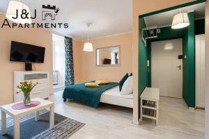 トルンにあるJ&J Apartments - Szczytna 1, Apartament 10のベッドルーム(ベッド1台、テレビ、テーブル付)
