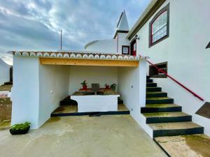 a church with a stairway leading to a white building at Casa do Avô José Alves in Praia da Vitória
