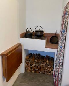 a room with a pile of fire wood and two pots at Casa do Avô José Alves in Praia da Vitória