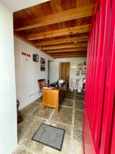 a living room with red curtains and a desk at Casa do Avô José Alves in Praia da Vitória