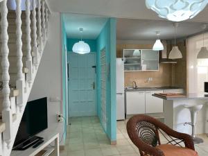 a kitchen with a blue door and a table and chairs at Duplex Las Americas in Playa de las Americas