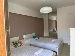 a bedroom with two beds and a mirror at Duplex Las Americas in Playa de las Americas